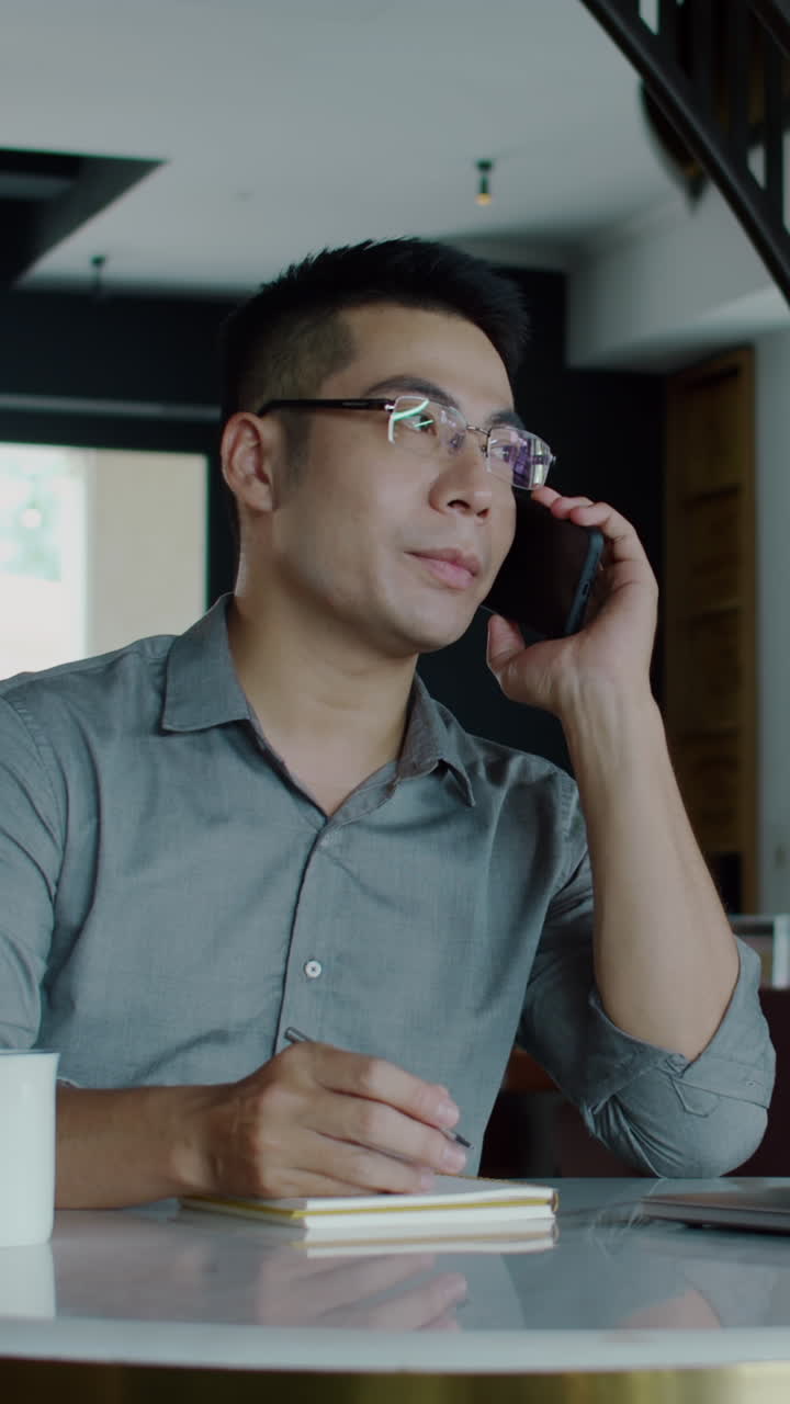 Consultant Talking with Client on Mobile Phone in Office