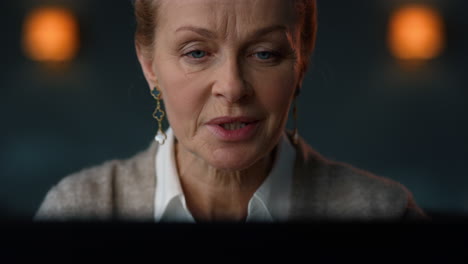 old woman talking at online meeting on laptop computer.