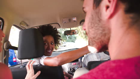 four friends driving in a car, view from the back seat