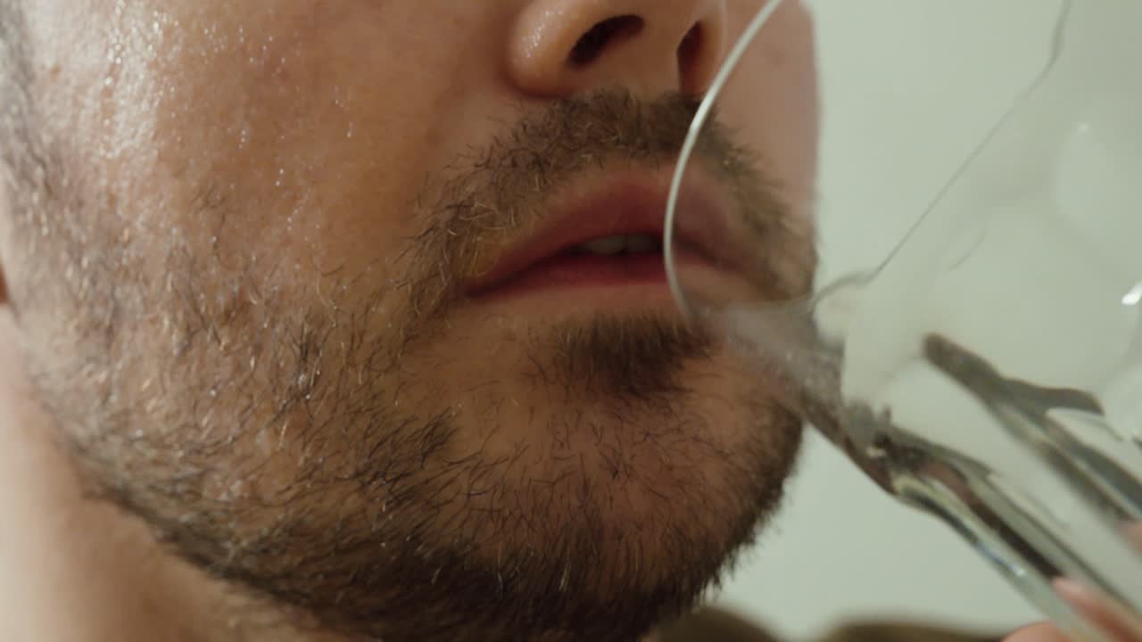 Close-up de um homem diabético suando e tremendo enquanto bebe suco de laranja para aumentar rapidamente os níveis de açúcar no sangue, ilustrando sintomas de hipoglicemia e resposta urgente de autocuidado.