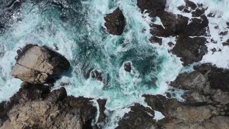 Breaking-Waves-Into-Rocky-Outcrops-At-The-Summer-Beach-Paradise