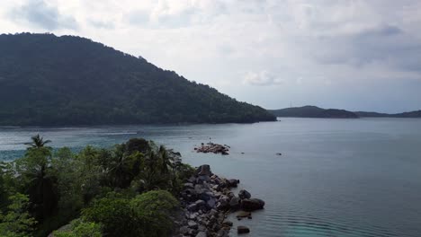 Scenic Tropical Island Bay with Lush Mountains and Rocky Coast