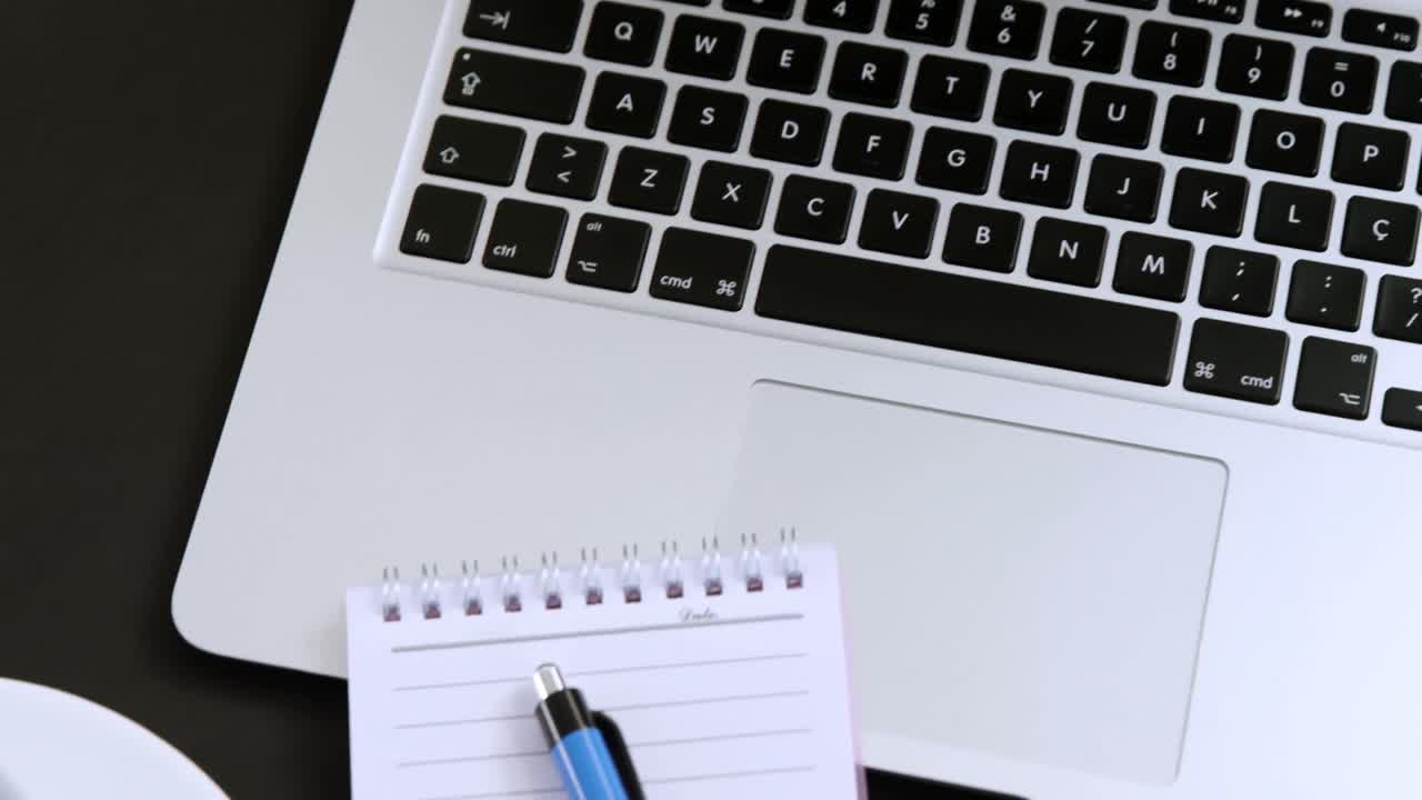 Laptop, notepad, coffee and pen on black background 4k