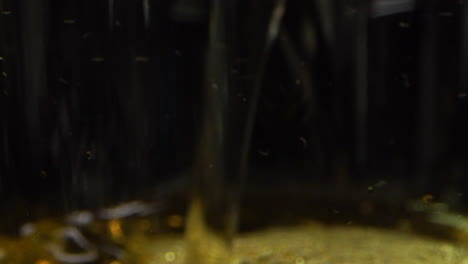 extreme closeup of cider flows into a cup in slow motion