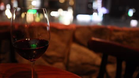 vaso de vino con luces de la ciudad en el fondo