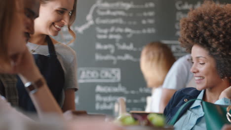 Fröhliche-Gruppe-Von-Freunden,-Die-Im-Café-Rumhängen-Und-Sich-Unterhalten,-Sich-Unterhalten-Und-Das-Gesellige-Beisammensein-Im-Café-Genießen