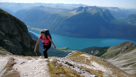 woman hiking in the mountains with a beautiful lake view