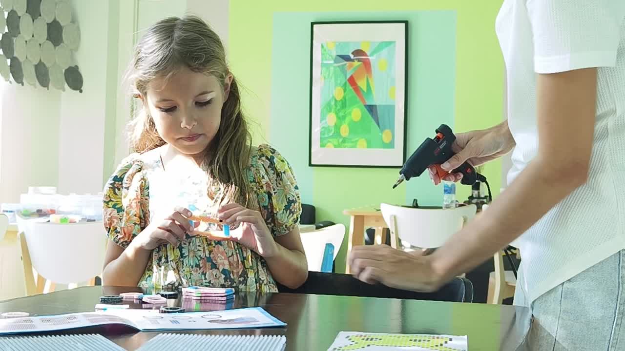 madre e hija haciendo artesanía juntos