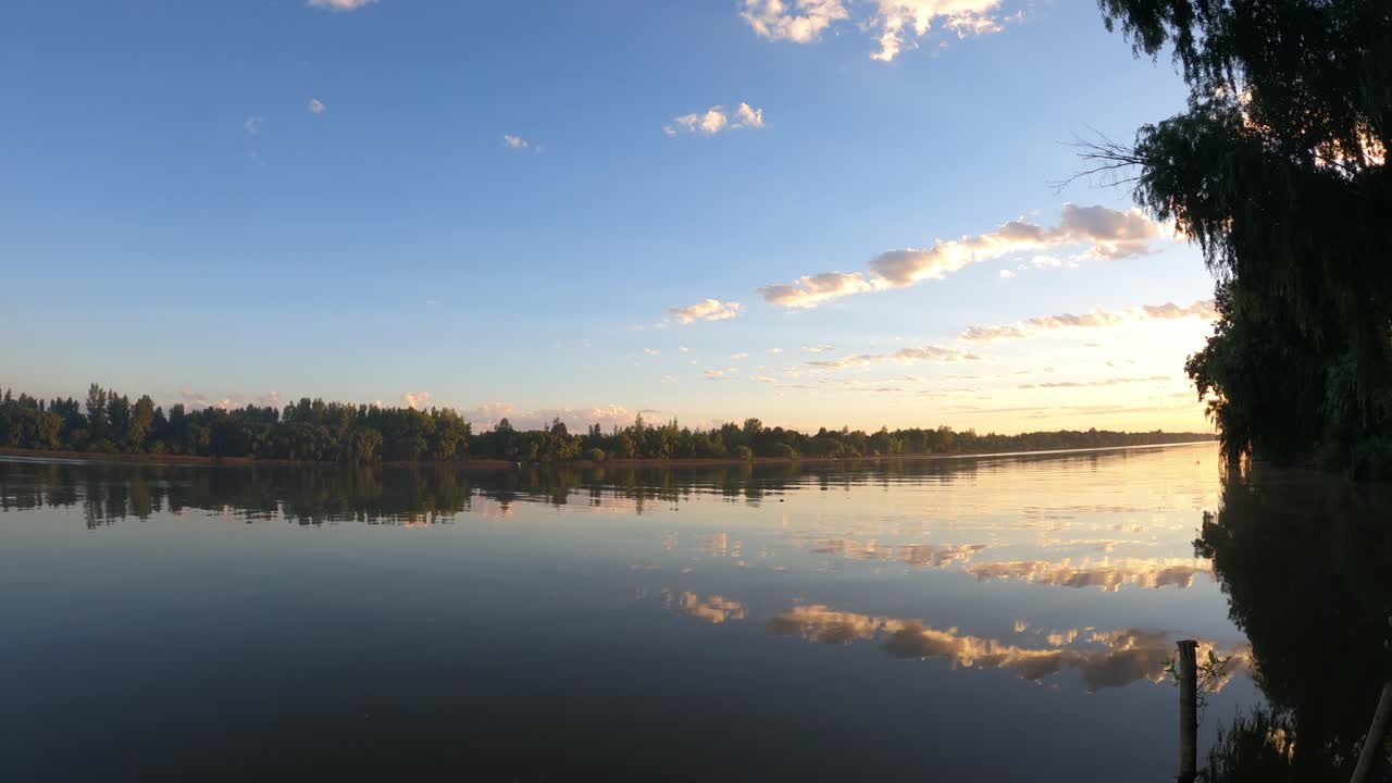 Ripresa in time-lapse di una bellissima alba colorata sul Rio delle Amazzoni con riflesso sull'acqua. Nuvole che si muovono nel cielo sereno.