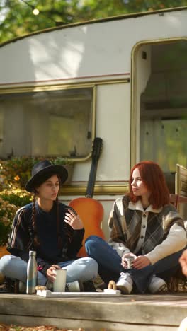 two women relaxing in autumn campground