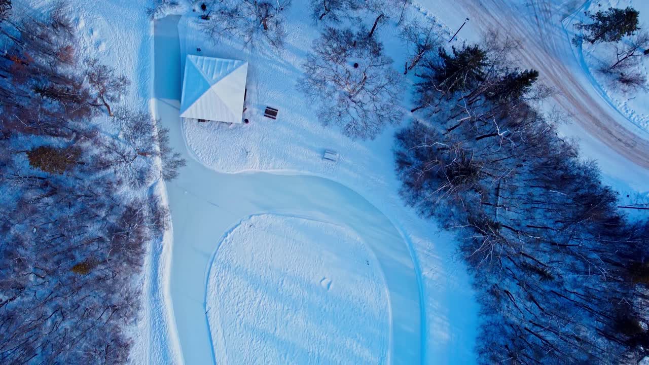 공중 겨울 황혼 조감도 비행 에드먼튼의 빅토리아 공원 인공 아이스 스케이팅 경주 트랙은 거의 무한대 모양으로 캐나다 최대의 야외 지자체 경기장 1-4에 연결됩니다.