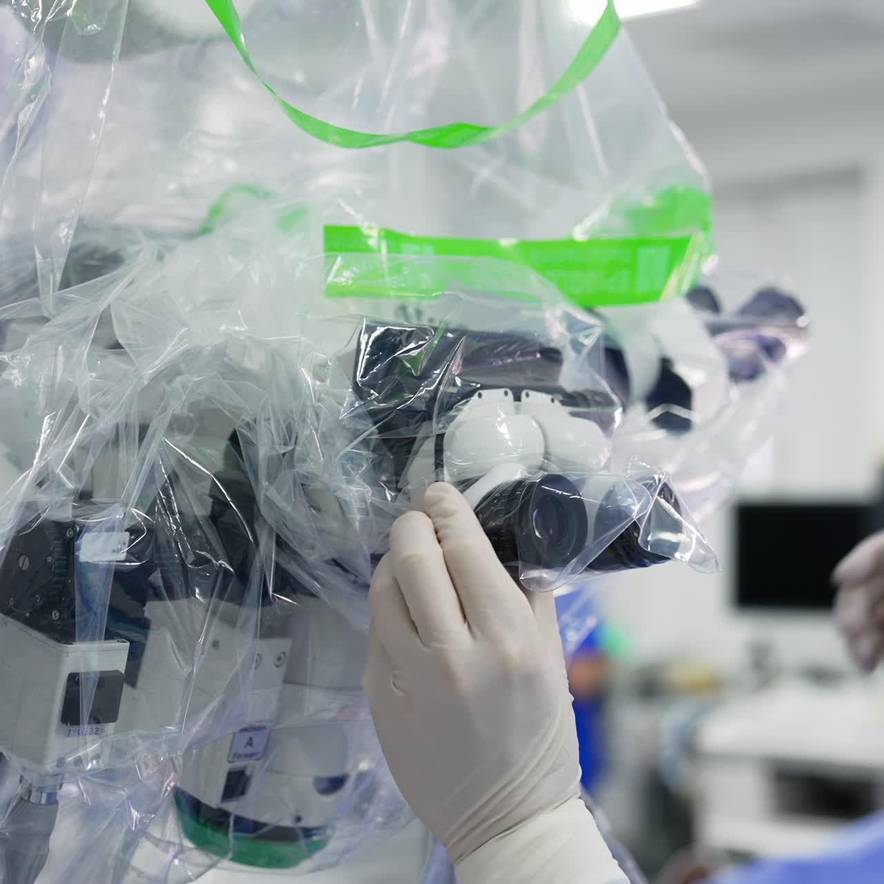 Modern technological equipment is being prepared for usage in surgery. Male specialist covering the powerful microscope in plastic