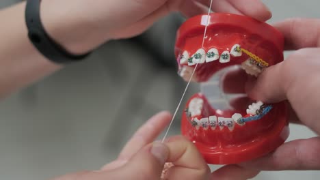 teeth with brace cleaning explanation, brush your teeth with a toothbrush the right way. dentist and dental hygienist explains how to clean your teeth.