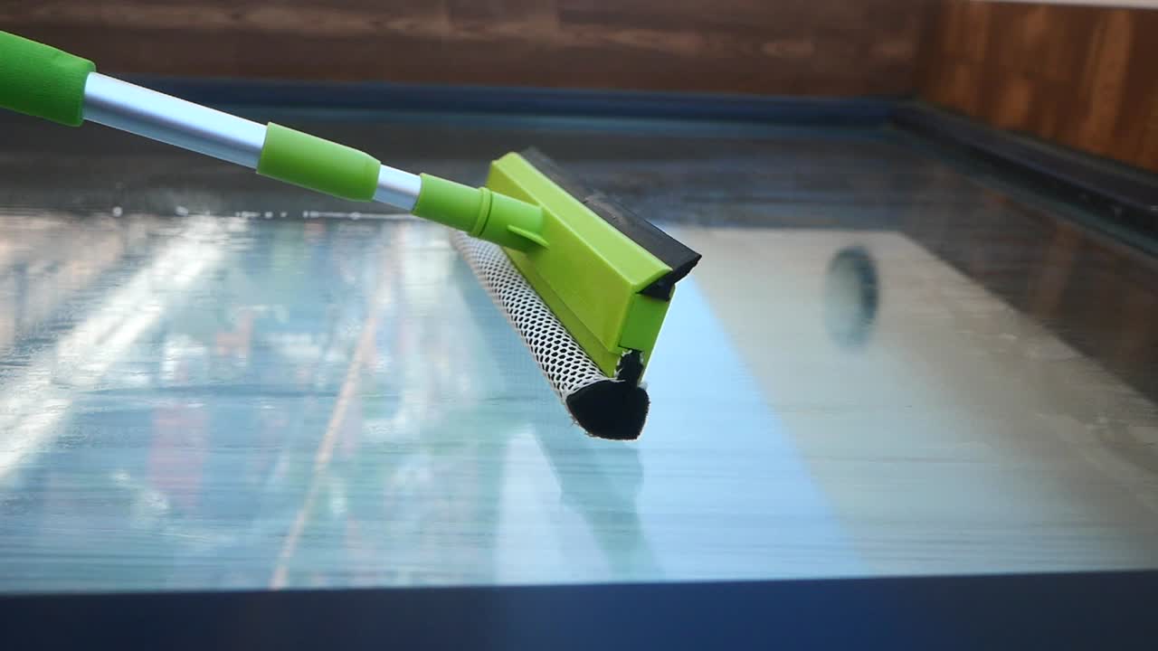 Cleaning a glass surface with a squeegee