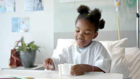 Afroamerikanisches-Mädchen-Isst-Mittagessen-Im-Krankenhausbett,-Zeitlupe