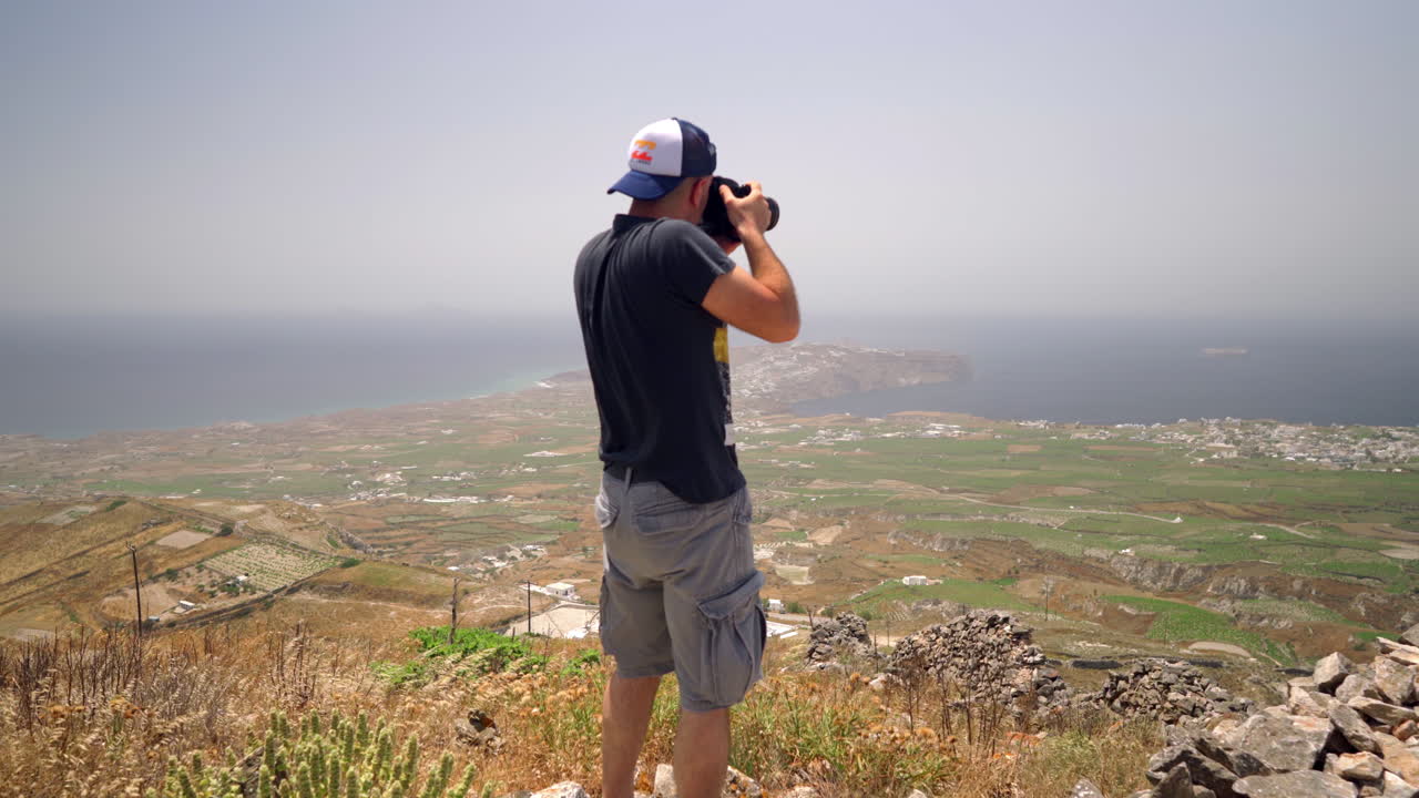 One man takes pictures on a hill of Santorini island in Greece