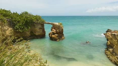 Grünes-Gras-Zeigte-Natürliche-Brücke-In-Der-Nähe-Des-Leuchtturms-Los-Morillos,-Cabo-Rojo,-Puerto-Rico