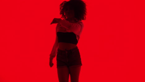 silhouette of a woman dancing in red light