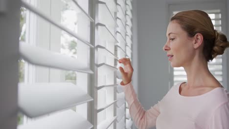 mujer mirando por la ventana en una casa cómoda 4k