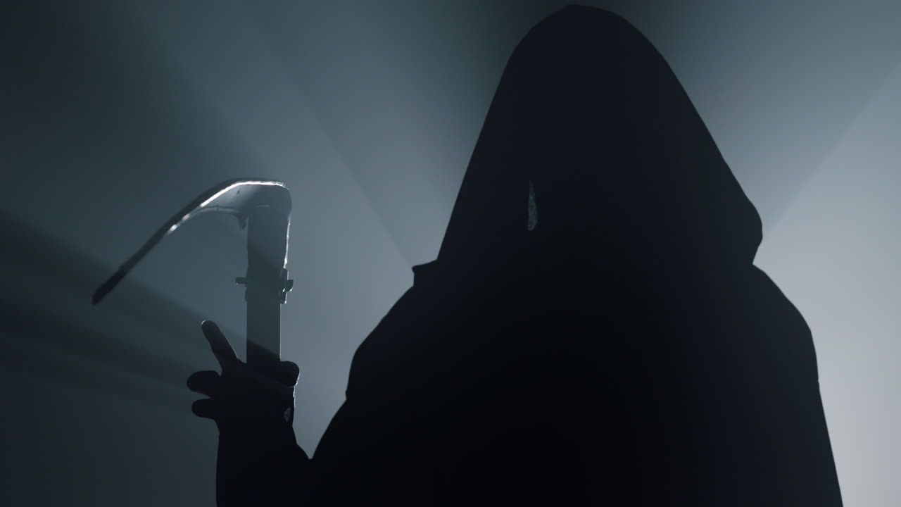 Silhouette death with scythe indoors. Man in costume grim reaper on halloween .