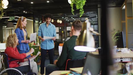 Happy-disabled-and-diverse-business-people-discussing-work-at-office