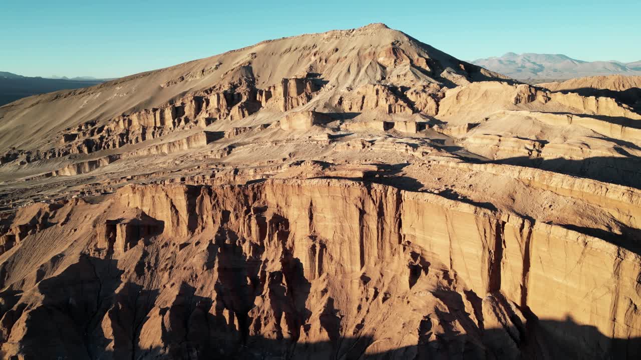 Aerial drone view of Chile’s Valle de la Luna at sunset, showcasing surreal desert ridges and glowing rock formations in the Atacama Desert