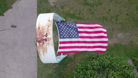 Aerial-video-of-the-American-Flag-blowing-vertical-in-the-wind,-Rocky-Point,-RI