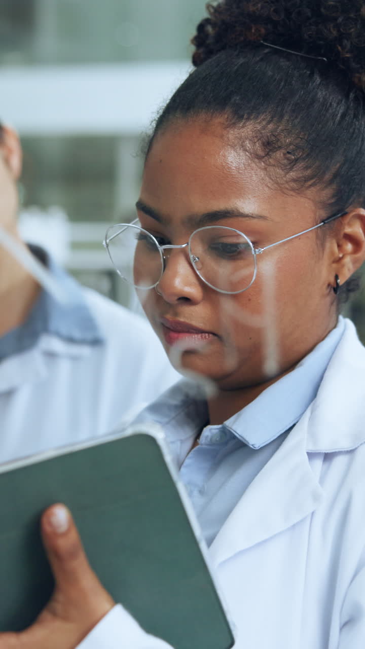 Scienziata che discute dati di ricerca su tablet in laboratorio