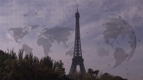 Animation-of-world-map-and-spinning-globe-against-view-of-eiffel-tower