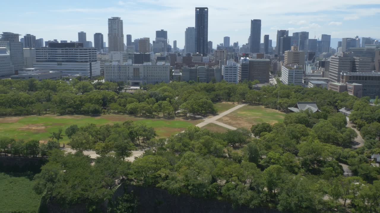 Lush Green Nature Overlooking Cityscape At Nishinomaru Garden In Osaka, Japan. Aerial Wide Shot