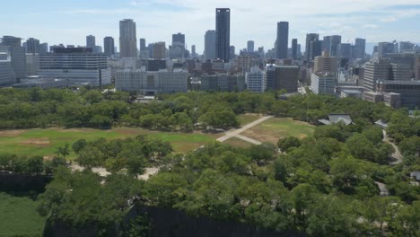 lush green nature overlooking cityscape at nishinomaru garden in osaka, japan. aerial wide shot