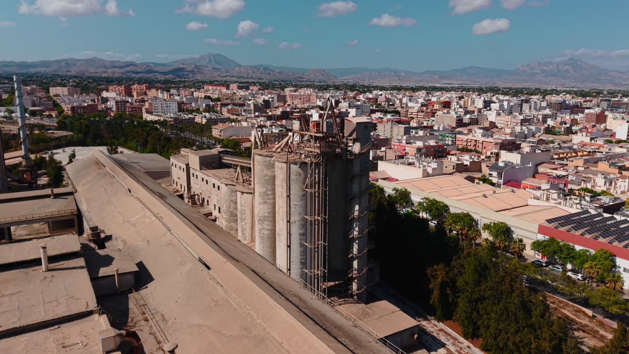 Vista aerea di una città con impianti industriali e montagne
