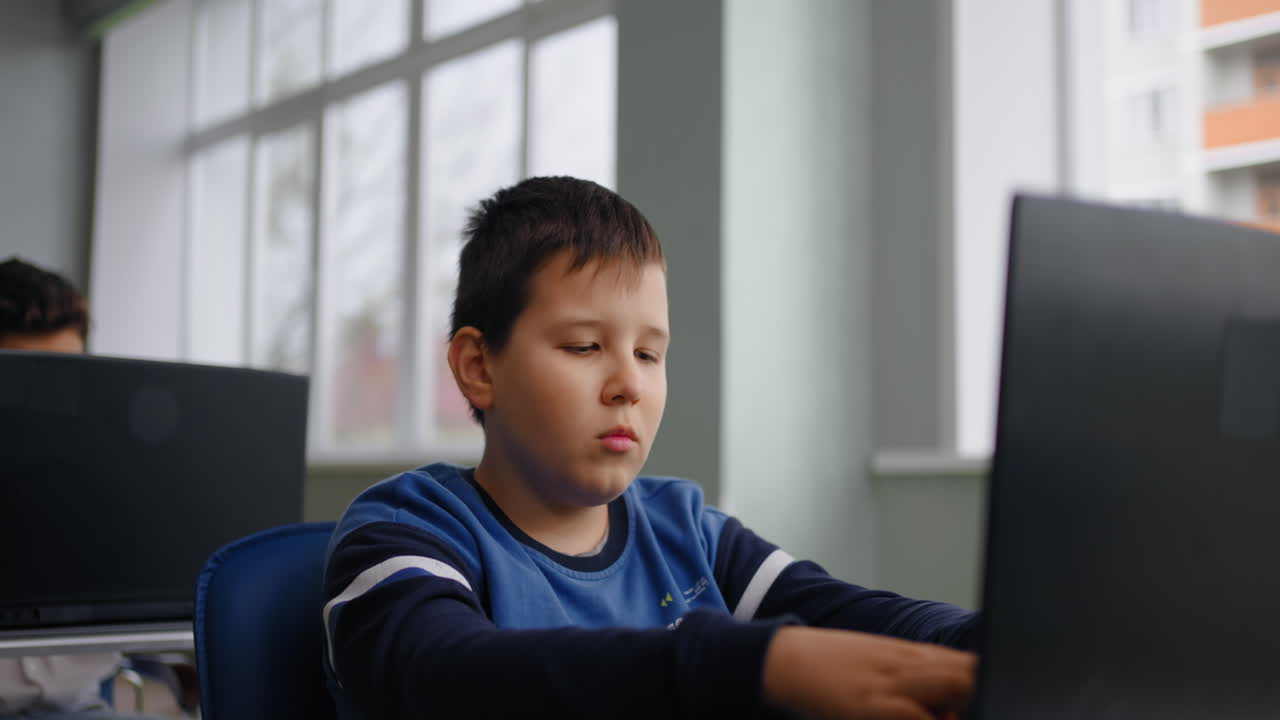 niño estudiando en la computadora portátil en el aula
