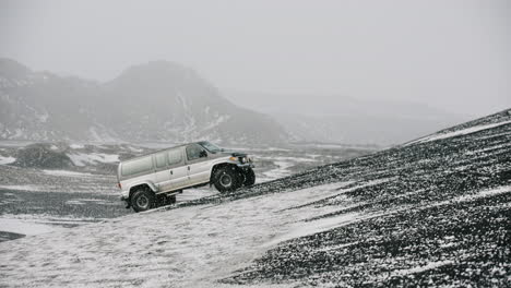 snow-covered icelandic landscape with a van driving uphill