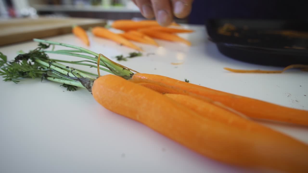 Mano che raccoglie una carota in cucina