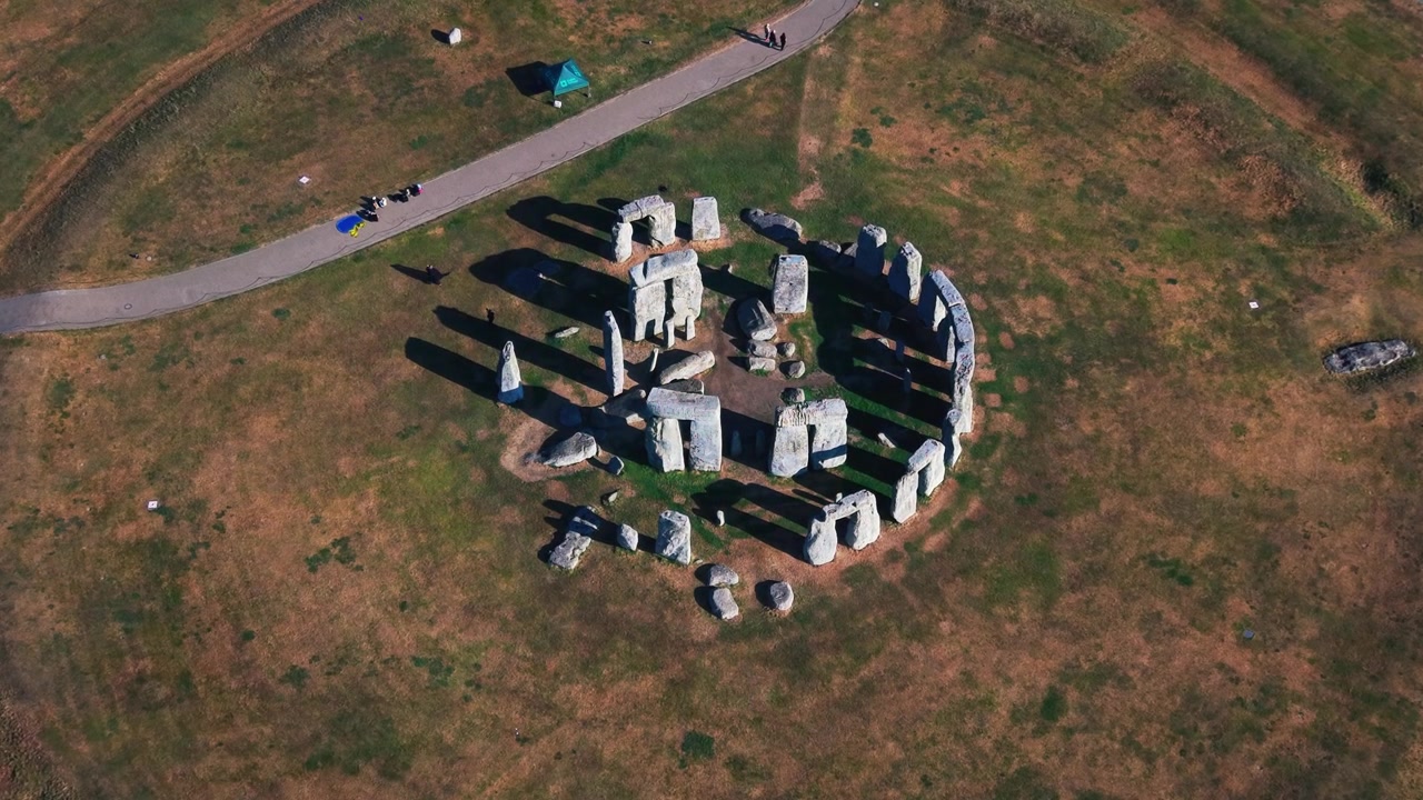 Droneopptak ovenfra av Stonehenge på Salisbury Plain i Wiltshire, England. Høyvinkelutsikten viser tydelig den forhistoriske steinsirkelen, stående steiner og lange skygger