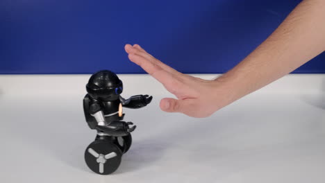 hand stopping a toy robot