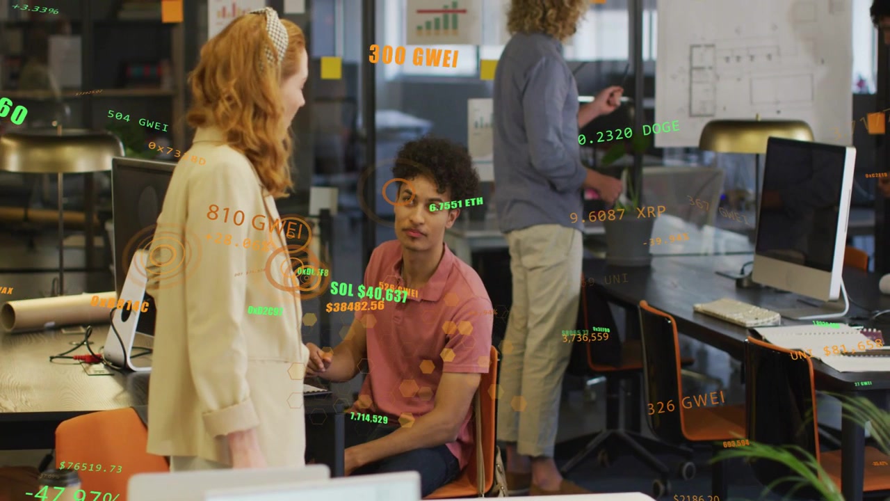 Talking seated man in pink polo pointing at keyboard in office, with floating numeric graphics