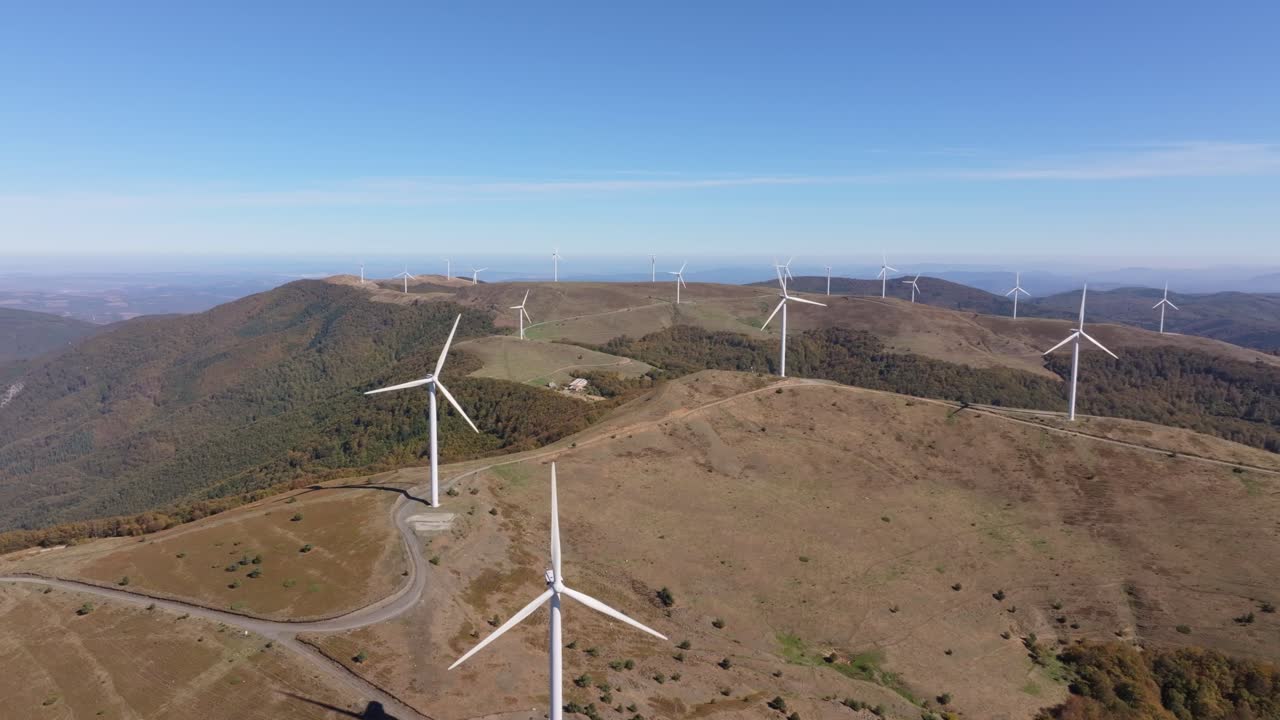 Pás giratórias pontilham as terras altas ensolaradas perto de Enina, Bulgária