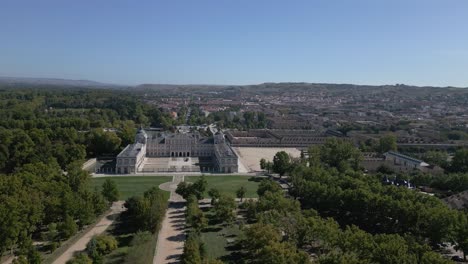cinematic drone flight in the surroundings of the royal palace of aranjuez in its entirety, we see the paths that lead to it, the esplanade of the couples, the house of trades, behind the town.