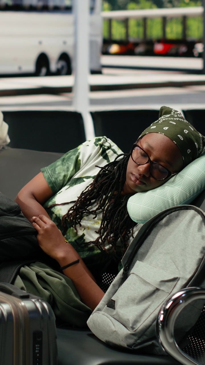 Young Woman Sleeping on Airport Bench While Waiting for Flight