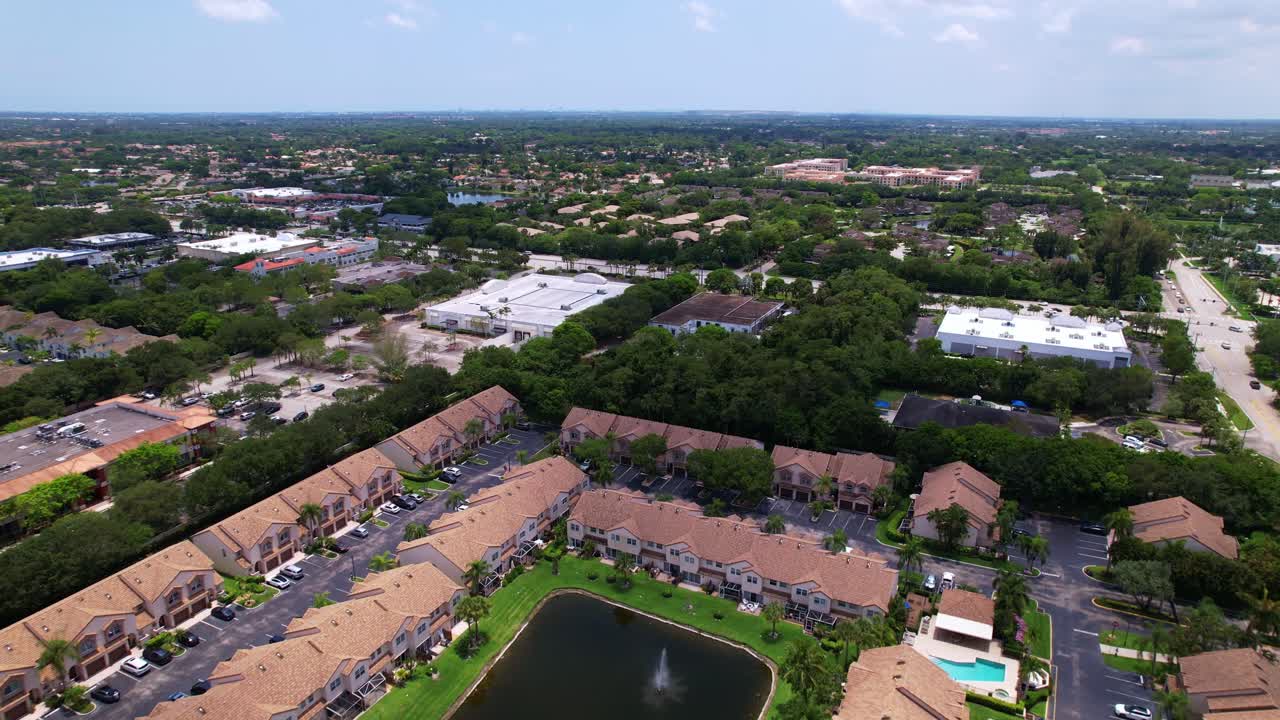 Drone footage over residential area with green lawns and rows of houses