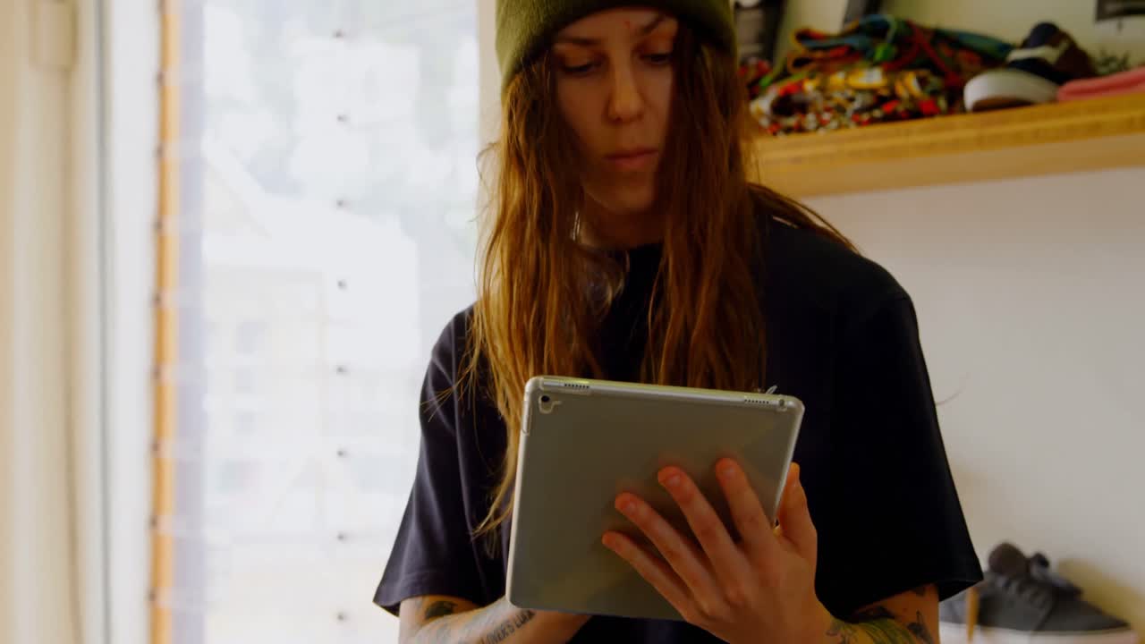 vista frontal de una joven mujer caucásica usando una tableta digital en un taller 4k