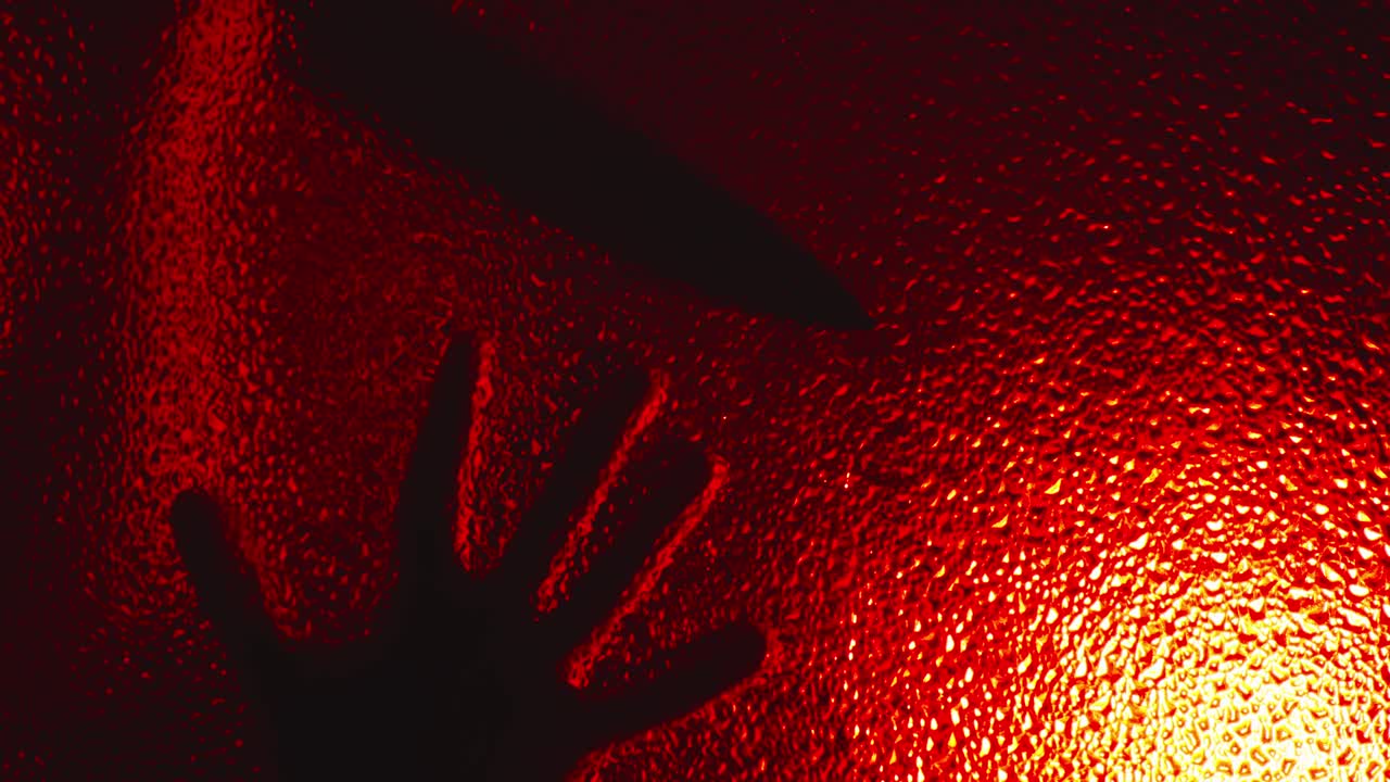 la aterradora silueta de un asesino poseído se arrastra por el vidrio, abre lentamente la puerta en la oscuridad bajo una siniestra luz roja