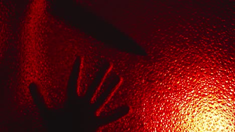 la aterradora silueta de un asesino poseído se arrastra por el vidrio, abre lentamente la puerta en la oscuridad bajo una siniestra luz roja