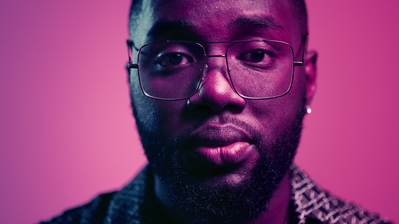 hombre afro serio levantando la cabeza en el interior. hombre enfocado mirando a la cámara en el interior