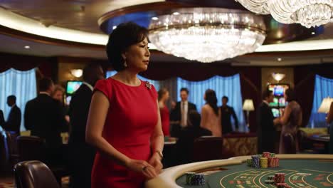 a glamorous evening at the casino: a woman in red engaging in high-stakes gaming amidst a lavish environment filled with elegantly dressed patrons and vibrant lights
