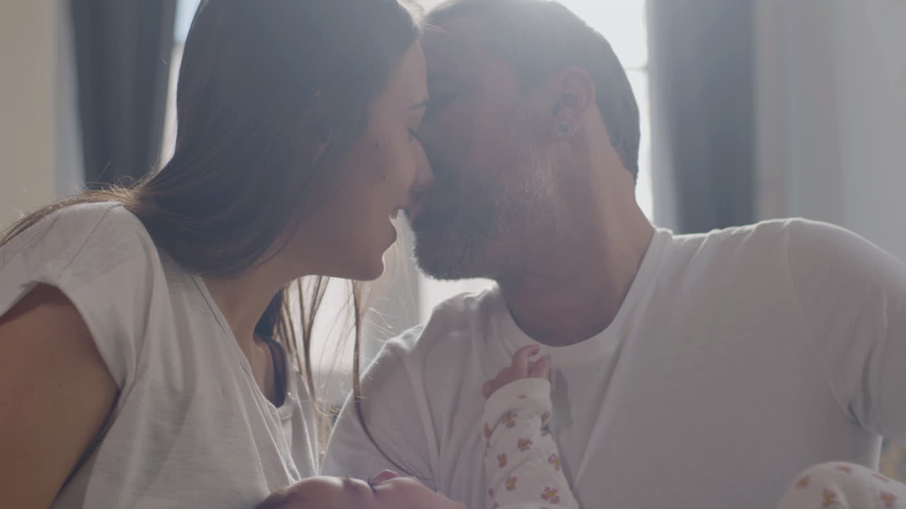 Coppia affettuosa che gioca con la loro bambina a letto di domenica mattina