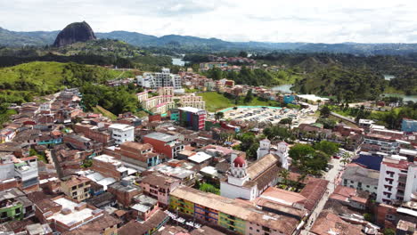 bird's-eye view of the town of guatapé with the giant granite rock in the horizon, in antioquia, colombia.
