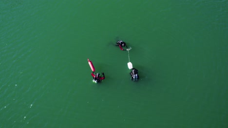 Aerial-shot-overhead-3-divers-out-conducting-training-in-Lac-du-Crès,-France